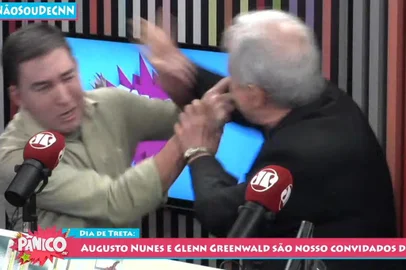  O comentarista da rádio Jovem Pan e da TV Record e colunista da revista Veja Augusto Nunes agrediu o jornalista Glenn Greenwald durante a transmissão ao vivo do programa Pânico, da Jovem Pan, após ser chamado de covarde. Por causa do incidente, o programa teve de ser interrompido pelo apresentador, Emílio Surita. (Reprodução/Jovem Pan)