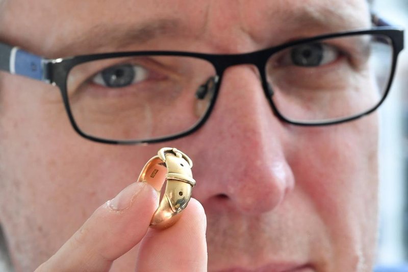 Arthur Brand, also dubbed the Indiana Jones of the Art World, poses with an 18-carat golden ring, which is said to have belonged to Irish playwright Oscar Wilde (1854-1900), at his apartment in Amsterdam on October 30, 2019. - A golden ring once given as a present by the famed Irish writer Oscar Wilde has been recovered by a Dutch art detective nearly 20 years after it was stolen from Britains Oxford University. The friendship ring, a joint gift from Wilde to a fellow student in 1876, was taken during a burglary in 2002 at Magdalen College, where the legendary dandy studied. At the time it was valued at GBP 35,000 (40,650 euros, USD 45,000). The trinkets whereabouts remained a mystery for years and there were fears that the ring -- shaped like a belt and buckle and made from 18-carat gold -- had even been melted down. But Arthur Brand, a Dutchman dubbed the Indiana Jones of the Art World for recovering a series of high-profile stolen artworks, used his underworld connections to finally find it. (Photo by JOHN THYS / AFP)