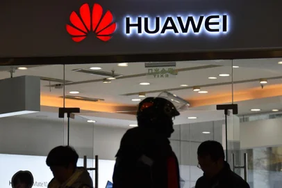  This photo taken on December 10, 2018 shows people walking past a Huawei store in Beijing. - Chinas ambitious drive to dominate next-generation 5G technology faces a sudden reality check as fears spread that telecom companies like Huawei could be proxies for Beijings intrusive security apparatus. (Photo by Greg Baker / AFP) / TO GO WITH China-US-telecommunication-diplomacy-Huawei-5G, FOCUS by Dan MartinEditoria: FINLocal: BeijingIndexador: GREG BAKERSecao: telecommunication serviceFonte: AFPFotógrafo: STF