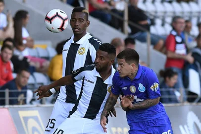 Nacionals Honduran forward Bryan Rochez (L) and Nacionals Brazilian midfielder Diego Barcelos (C) vie for the ball with Portos Brazilian forward Otavio during the Portuguese League football match between Nacional and Porto at the Madeira Stadium in Funchal on May 12, 2019. (Photo by HELDER SANTOS / AFP)