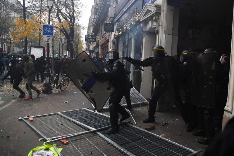 French anti-riot police officers charge during a demonstration against the pension overhauls, on Place de la Nation in Paris, on December 5, 2019, as part of a national general strike. - Trains cancelled, schools closed: France scrambled to make contingency plans on for a huge strike against pension overhauls that poses one of the biggest challenges yet to French Presidents sweeping reform drive. (Photo by Alain JOCARD / AFP)<!-- NICAID(14349598) -->