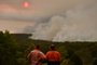 Residents watch a large bushfire as seen from Bargo, 150km southwest of Sydney, on December 19, 2019. - A state of emergency was declared in Australias most populated region on December 19 as an unprecedented heatwave fanned out-of-control bushfires, destroying homes and smothering huge areas with a toxic smoke. (Photo by Peter PARKS / AFP)<!-- NICAID(14363904) -->