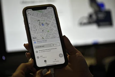 A woman checks the Uber transport application on her mobile phone after authorities ordered its suspension in Colombia, in Bogota on December 20, 2019. (Photo by Juan BARRETO / AFP)