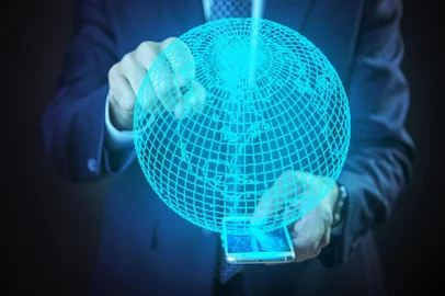 Futuristic senior business man booking a flightPORTO ALEGRE, RS, BRASIL, projetação do globo terrestre a partir do seu telefone, holograma (Foto:  Teodor Lazarev / stock.adobe.com)Indexador: Ä?orÄ`e SaviÄ¿ (Teodor Lazarev)Fonte: 193363555