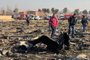 People walk near the wreckage after a Ukrainian plane carrying 176 passengers crashed near Imam Khomeini airport in Tehran early in the morning on January 8, 2020, killing everyone on board. - The Boeing 737 had left Tehran's international airport bound for Kiev, semi-official news agency ISNA said, adding that 10 ambulances were sent to the crash site. (Photo by - / AFP)