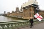 A man carries a flag of St George, the English national flag, along with a Union Flag as he walks along Westminster Bridge by the Houses of Parliament in London on January 31, 2020 on the day that the UK formally leaves the European Union. - Britain on January 31 ends almost half a century of integration with its closest neighbours and leaves the European Union, starting a new -- but still uncertain -- chapter in its long history. (Photo by Glyn KIRK / AFP)<!-- NICAID(14404325) -->