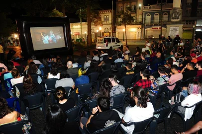  CAXIAS DO SUL, RS, BRASIL, 02/02/2020. Exibição do filme Priscilla, A Rainha do Deserto, como parte da programação do Cinema de Verão, levou dezenas de pessoas à Praça Dante Alighieri neste domingo. Claudiana Oliveira, 45, aproveitou a ocasião para levar a mãe, Maria Isabel Oliveira, 74, e a periquita australiana Chulapinha, para curtir a sessão gratuita e a céu aberto. O evento também contou com a participação de drag queens que recepcionaram o público. (Porthus Junior/Agência RBS)