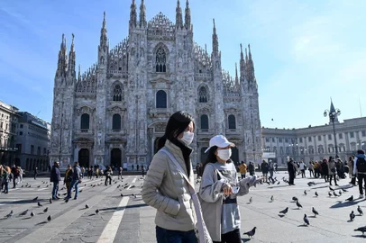  Two women wearing a protective facemask walk across the Piazza del Duomo, in front of the Duomo, in central Milan, on February 24, 2020 closed following security measures taken in northern Italy against the COVID-19 the novel coronavirus. - Italy reported on February 24, 2020 its fourth death from the new coronavirus, an 84-year old man in the northern Lombardy region, as the number of people contracting the virus continued to mount. (Photo by ANDREAS SOLARO / AFP)Editoria: HTHLocal: MilanIndexador: ANDREAS SOLAROSecao: diseaseFonte: AFPFotógrafo: STF