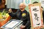  In this handout picture taken and released by Guineess World Records LTD. via Jiji Press on February 12, 2020 Japanese Chitetsu Watanabe, aged 112, poses next to the calligraphy reading in Japanese World Number One after he was awarded as the worlds oldest living male in Joetsu, Niigata prefecture. - A 112-year-old Japanese man who believes smiling is the key to longevity has been recognised as the worlds oldest male, Guinness World Records said on February 12, 2020. (Photo by STR / 2019 Guinness World Records Ltd via Jiji Press / AFP) / Japan OUT / RESTRICTED TO EDITORIAL USE - MANDATORY CREDIT AFP PHOTO /  2019 GUINNESS WORLD RECORDS LTD. / JIJI PRESS - NO MARKETING - NO ADVERTISING CAMPAIGNS - DISTRIBUTED AS A SERVICE TO CLIENTSEditoria: HUMLocal: JoetsuIndexador: STRSecao: peopleFonte: 2019 Guinness World Records Ltd Fotógrafo: STR<!-- NICAID(14417152) -->
