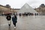  Two people walk away from the Pyramid, the main entrance to the Louvre museum which was once a royal residence, located in central in Paris on March 2, 2020. - The Louvre in Paris, the worlds most visited museum, was closed for a second day running on March 2, 2020, after staff refused for a second day running to work due to coronavirus fears, a union said. The Paris museum insisted that closure was not necessary in response to fears over the virus, which has spread to over 60 countries after first emerging in China late last year. (Photo by Ludovic Marin / AFP)Editoria: HTHLocal: ParisIndexador: LUDOVIC MARINSecao: diseaseFonte: AFPFotógrafo: STF<!-- NICAID(14436817) -->
