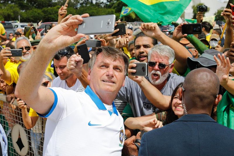  Brazilian President Jair Bolsonaro greets supporters in front of the Planalto Palace, after a protest against the National Congress and the Supreme Court, in Brasilia, on March 15, 2020. (Photo by Sergio LIMA / AFP)Editoria: POLLocal: BrasíliaIndexador: SERGIO LIMASecao: diseaseFonte: AFPFotógrafo: STR<!-- NICAID(14452062) -->