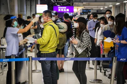 A health official checks the temperature of an incoming passenger during a health assessment at a checkpoint for people flying in from a list of countries and territories that include China, Hong Kong, Macau, South Korea, Iran and Italy, as a precautionary measure against the spread of the COVID-19 coronavirus at Suvarnabhumi Airport in Bangkok on March 9, 2020. (Photo by VIVEK PRAKASH / AFP)<!-- NICAID(14452733) -->