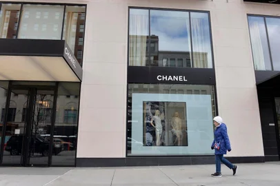 A women walks by a closed Chanel shop in Boston, Massachusetts on March 24, 2020. - Massachusetts Governor Charlie Baker issued an order to close all non-essential businesses and an advisory for the public to stay at home that went into effect at noon on March 24, 2020 to reduce the spread of the Covid-19 virus. (Photo by Joseph Prezioso / AFP) coronavírus<!-- NICAID(14463862) -->