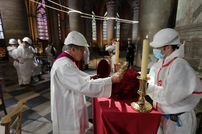 Notre-Dame de Paris cathedrals rector Patrick Chauvet repositions the Crown of Thorns, a relic of the passion of Christ, after a meditation ceremony to celebrate Good Friday in a secured part of Notre-Dame de Paris cathedral on April 10, 2020, in Paris on the 25th day of a strict lockdown aimed at curbing the spread of the COVID-19 pandemic, caused by the novel coronavirus. - Notre-Dame, part of a UNESCO world heritage site on the banks of the River Seine, was ravaged by the April 15 blaze -- losing its gothic spire, roof and many precious artefacts. (Photo by Ludovic MARIN / POOL / AFP)