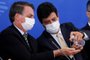(FILES) In this file photo taken on March 18, 2020, Brazilian President Jair Bolsonaro (L) and his Health Minister Luiz Henrique Mandetta sanitize their hands wearing face masks during a press conference related to the new coronavirus, COVID-19, at the Planalto Palace in Brasilia, Brazil. - The Brazilian Minister of Health, Luiz Henrique Mandetta, has used a mixture of technical experience and political audacity to lead from science the fight against the coronavirus, antagonizing President Jair Bolsonaro, a skeptic about the pandemic that critices him for lack of humility. (Photo by Sergio LIMA / AFP)<!-- NICAID(14474721) -->