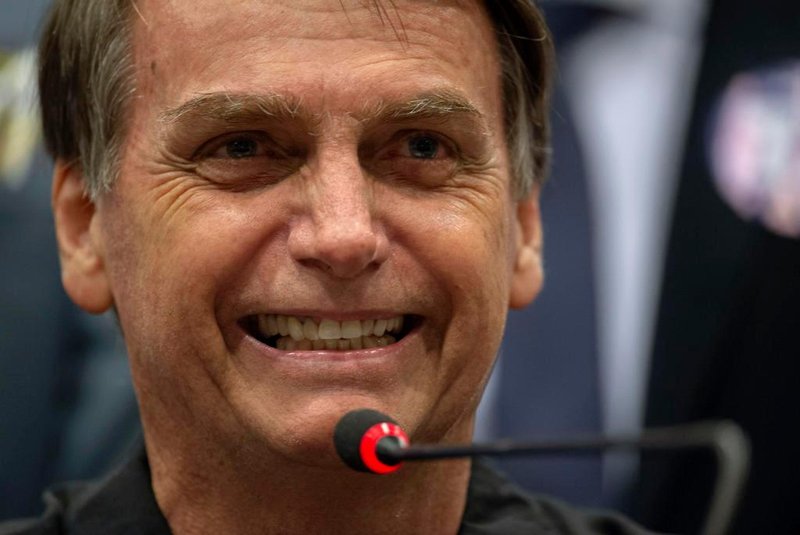 Brazils right-wing presidential candidate for the Social Liberal Party (PSL) Jair Bolsonaro gestures during a press conference in Rio de Janeiro, Brazil on October 11, 2018. - The far-right frontrunner to be Brazils next president, Jair Bolsonaro, stumbled Wednesday by spooking previously supportive investors, while a spate of violent incidents pointed to deep polarization caused by the election race. (Photo by Mauro Pimentel / AFP)<!-- NICAID(13781822) -->