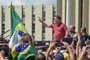 Brazilian President Jair Bolsonaro speaks after joining his supporters who were taking part in a motorcade to protest against quarantine and social distancing measures to combat the new coronavirus outbreak in Brasilia on April 19, 2020. (Photo by EVARISTO SA / AFP)<!-- NICAID(14481427) -->