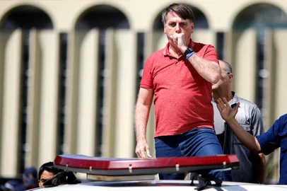  Brazilian President Jair Bolsonaro coughs as he speaks after joining his supporters who were taking part in a motorcade to protest against quarantine and social distancing measures to combat the new coronavirus outbreak in Brasilia on April 19, 2020. (Photo by Sergio LIMA / AFP)Editoria: HTHLocal: BrasíliaIndexador: SERGIO LIMASecao: diseaseFonte: AFPFotógrafo: STR<!-- NICAID(14481581) -->