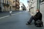 A homeless man sits in a deserted Via del Corso main street in central Rome on March 24, 2020 during the countrys lockdown aimed at stopping the spread of the COVID-19 (new coronavirus) pandemic. (Photo by Vincenzo PINTO / AFP)<!-- NICAID(14460223) -->