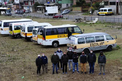  CAXIAS DO SUL, RS, BRASIL, 06/05/2020. Edson Borges dos Santos, 48, e a esposa Elisângela Pereira da Silva, 42, trabalham há 17 anos com vans escolares. Os dois veículos estão parados e o casal vive a incerteza de quando voltará a trabalhar. Na foto, Edson Borges (4º da D p/ E de jeans, boné e braços cruzados),  junto com outros motoristas de vans. (Porthus Junior/Agência RBS)<!-- NICAID(14493962) -->