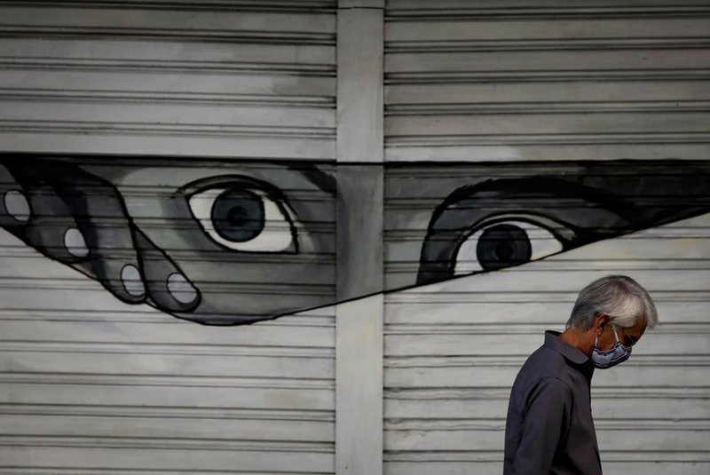  PORTO ALEGRE, RS, BRASIL, 20-04-2020, 13h: Pedestre com máscara no rosto caminha em frente a um grafite na avenida Borges de Medeiros, sob o viaduto Otávio Rocha. (Foto: Mateus Bruxel / Agência RBS)Indexador: Mateus Bruxel<!-- NICAID(14482074) -->