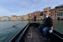 A gondolier wearing a face mask (Rear) transports his very first customer as service resumes at the San Toma embankment on a Venice canal on May 18, 2020 during the countrys lockdown aimed at curbing the spread of the COVID-19 infection, caused by the novel coronavirus. - Restaurants and churches reopen in Italy on May 18, 2020 as part of a fresh wave of lockdown easing in Europe and the countrys latest step in a cautious, gradual return to normality, allowing businesses and churches to reopen after a two-month lockdown. (Photo by ANDREA PATTARO / AFP)
