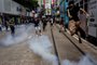 Police fire tear gas on protesters during a planned protests against a proposal to enact a new security legislation in Hong Kong on May 24, 2020. - The proposed legislation is expected to ban treason, subversion and sedition, and follows repeated warnings from Beijing that it will no longer tolerate dissent in Hong Kong, which was shaken by months of massive, sometimes violent anti-government protests last year. (Photo by ISAAC LAWRENCE / AFP)<!-- NICAID(14506791) -->