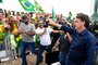 Brazils President Jair Bolsonaro greets supporters upon arrival at Planalto Palace in Brasilia, on May 24, 2020, amid the COVID-19 coronavirus pandemic. - Despite positive signs elsewhere, the disease continued its surge in large parts of South America, with the death toll in Brazil passing 22,000 and infections topping 347,000, the worlds second-highest caseload. (Photo by EVARISTO SA / AFP)<!-- NICAID(14506800) -->