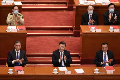 China's President Xi Jinping (C), Premier Li Keqiang (R) and Chairman of the Chinese People's Political Consultative Conference (CPPCC) Wang Yang (L) applaud after the vote on a proposal to draft a Hong Kong security law during the closing session of the National People's Congress at the Great Hall of the People in Beijing on May 28, 2020. - China's parliament approved plans on May 28 to impose a security law on Hong Kong that critics say will eradicate the city's promised freedoms. (Photo by NICOLAS ASFOURI / AFP)<!-- NICAID(14509745) -->