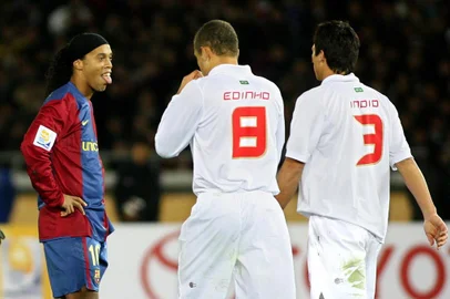 72812876Spain's FC Barcelona forward Ronaldinho (L) of Brazil puts out his tongue after missing a free kick as he stands beside Brazil's SC Internacional midfielder Edinho (C) and Indio (R) in the FIFA Club World Cup in Yokohama, 17 December 2006. FC Barcelona was defeated by SC International 1-0.    AFP PHOTO/Toru YAMANAKA (Photo by TORU YAMANAKA / AFP)Editoria: SPOLocal: YokohamaIndexador: TORU YAMANAKASecao: soccerFonte: AFP