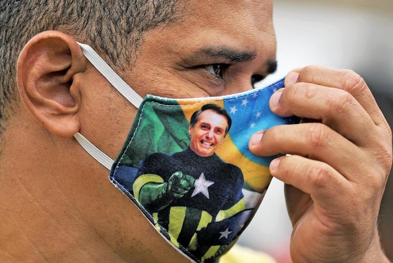  A supporter of President Jair Bolsonaro wears a face mask with Bolsonaros image during a demonstration at Copacabana beach in Rio de Janeiro, Brazil, on June 7, 2020. (Photo by CARL DE SOUZA / AFP)Editoria: POLLocal: BrasíliaIndexador: CARL DE SOUZASecao: demonstrationFonte: AFPFotógrafo: STF<!-- NICAID(14517188) -->
