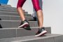 Running shoes runner woman walking up stairsStairs climbing running woman doing run up steps on staircase. Female runner athlete going up stairs in urban city doing cardio sport workout run outside during summer. Activewear leggings and shoes.Indexador: MaridavFonte: 152175418<!-- NICAID(14522523) -->