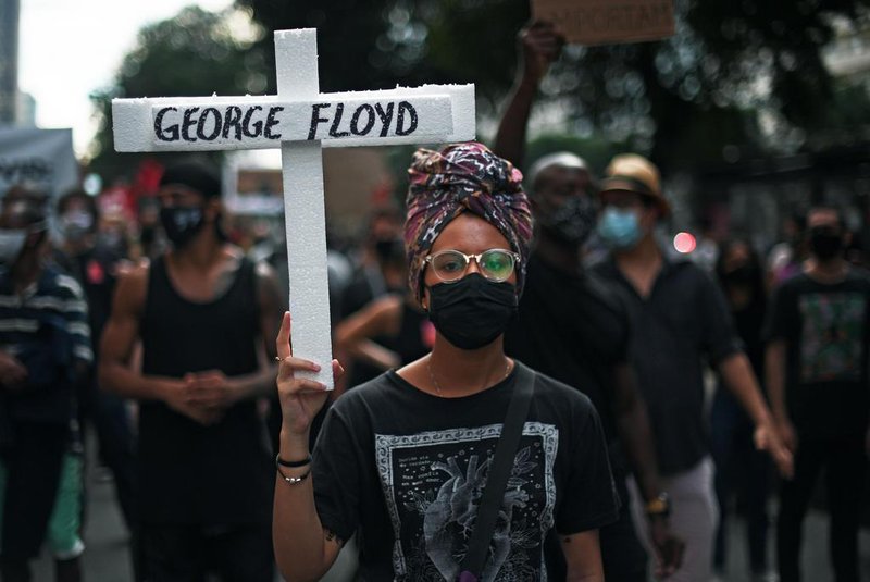  A protester holds a cross with the name of George Floyd, an unarmed black man killed while apprehended by police in Minneapolis, US, during a demonstration against racism and against Brazilian President Jair Bolsonaro in Rio de Janeiro, Brazil, on June 7, 2020 amid the COVID-19 novel coronavirus pandemic. - Brazilians took to the streets for rival demonstrations on Sunday for and against Bolsonaro, who has been widely criticized over his response to the coronavirus pandemic. Demonstrators, many dressed in black and wearing face masks, held banners saying: Everyone for democracy, Against racism and fascism and Terrorism is the governments policy of extermination. (Photo by Carl DE SOUZA / AFP)Editoria: HTHLocal: Rio de JaneiroIndexador: CARL DE SOUZASecao: racismFonte: AFPFotógrafo: STF<!-- NICAID(14517332) -->
