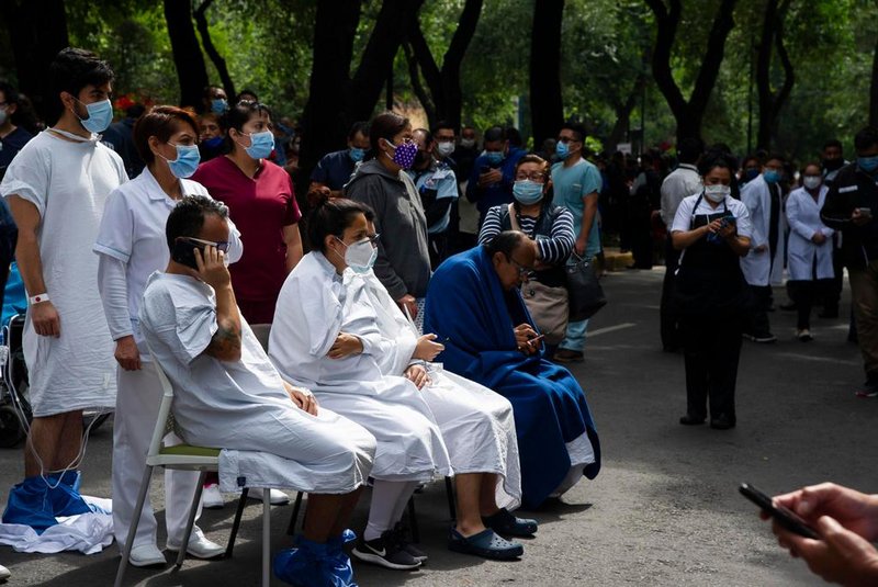  People remain outside the Durango clinic in Mexico City during a quake on June 23, 2020 amid the COVID-19 novel coronavirus pandemic. - A 7.1 magnitude quake was registered Tuesday in the south of Mexico, according to the Mexican National Seismological Service. (Photo by CLAUDIO CRUZ / AFP)Editoria: DISLocal: Mexico CityIndexador: CLAUDIO CRUZSecao: diseaseFonte: AFPFotógrafo: STR<!-- NICAID(14529029) -->