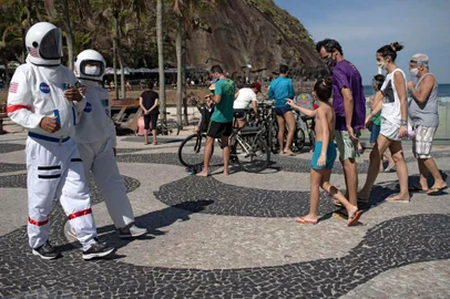 Brazilian accountant Tercio Galdino, 66, and his wife Alicea Galdino walk along Leme beach in protective suits, in Rio de Janeiro, Brazil on July 12, 2020. - Tercio, who has a chronic lung disease, made the protective suits (looking like astronauts gear) at home using suits used by health professionals. He says that, in addition to giving him protection against the new coronavirus, they also wear them for fun, as he has huge interest in astronomy. (Photo by Mauro Pimentel / AFP)Editoria: HTHLocal: Rio de JaneiroIndexador: MAURO PIMENTELSecao: diseaseFonte: AFPFotógrafo: STF<!-- NICAID(14544184) -->