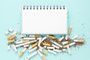Top view notebook with pile of cigarettesTop view notebook with pile of cigarettesFonte: 275264368<!-- NICAID(14576178) -->