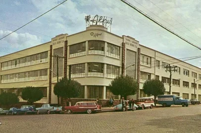 Imagem publicada no blog www.antigosverdeamarelo.blogspot.com. A foto é de 1966, tirada para uma cartão-postal da empresa Tecidos e Artefatos Kalil Sehbe S.A., produtos com a marca Alfred, de Caxias do Sul. Rua Marechal Floriano esquina com Sinimbu. Fundada em 1927. O grupo de empresas chegou a contar com 8 mil funcionários (entre elas as Lojas Alfred, Alfred Nordeste, da Av. Fernandes da Cunha, em Salvador, e Lanifício Sehbe, de Galópolis, além dos Hotéis Alfred). O nome dos proprietários dos veículos que aparecem::: A Jangada vermelha era do Vasco Fanchin :: A Jangada azul era do Ivan Marcon:: O Tufão Rallye 66 verde era do dr. Jorge Sehbe :: O Tufão marron era do Miguel Sehbe:: A Rural era do dr. Nelson Gallas:: O DKW, do Dario Lopes:: O VW azul (Fusca), do Idílio Farina:: O caminhão era uma F 350 da empresa <!-- NICAID(14588609) -->