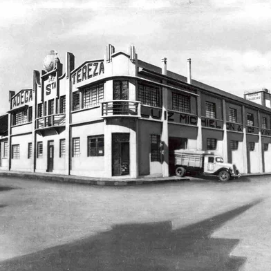 Complexo da antiga Vinícola Luiz Michielon, na esquina das ruas Luiz Michielon e Angelina Michielon, no bairro Lourdes. Globo, no topo do prédio, é um dos símbolos remanescentes do complexo arquitetônico. Na foto, o complexo nos anos 1940. Vê-se o símbolo dos Vinhos Cruzeiro acima do logotipo da Adega Santa Tereza, espaço que, de forma pioneira em Caxias, costumava receber visitantes, turistas e curiosos para a famosa ¿provinha¿ - a nossa atual ¿degustação¿.<!-- NICAID(14590851) -->