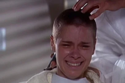 Carolina Dieckmann interpreta Camila na novela Laços de Família, de 2000. Na cena, ela rapas a cabeça devido ao câncer. 