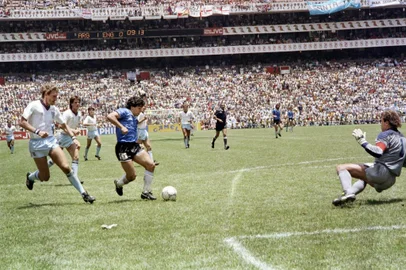  (FILES) In this file photo taken on June 22, 1986 Argentinian forward Diego Armando Maradona (3rd L) runs past English defender Terry Butcher (L) on his way to dribbling goalkeeper Peter Shilton (R) and scoring his second goal, or goal of the century, during the World Cup quarterfinal football match between Argentina and England in 1986 in Mexico City. - Argentinian football legend Diego Maradona passed away on November 25, 2020 (Photo by STAFF / AFP)Editoria: SPOLocal: Mexico CityIndexador: STAFFSecao: soccerFonte: AFPFotógrafo: STF<!-- NICAID(14652365) -->