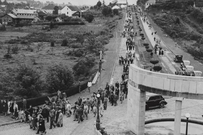 Funcionários da Metalúrgica Abramo Eberle  e moradores locais seguindo pela avenida Júlio de Castilhos em direção à praça Abramo Eberle, durante as comemorações do cinquentenário da firma. Na ocasião, houve celebração de missa campal seguida da inauguração do busto em homenagem ao fundador da metalúrgica, Abramo Eberle. Giacomo Geremia, 11/05/1946.<!-- NICAID(14661568) -->