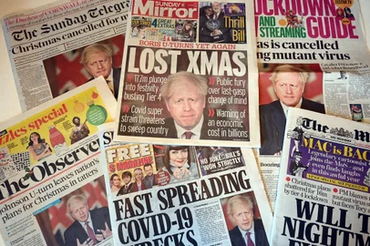  An arrangement of UK daily newspapers photographed as an illustration in Liverpool on December 20, 2020, shows front page headlines reporting on the story of Britains Prime Minister Boris Johnson introducing new tougher coronavirus COVID-19 restrictions for London and the South East of England, cancelling Christmas gatherings for those in the new tier 4 category. - British Prime Minister Boris Johnson on Saturday announced a stay at home order for London and southeast England to slow a new coronavirus strain that is significantly more infectious. He ordered new restrictions for London and south-eastern England from Sunday, saying that residents in those areas must stay at home at least until December 30. The measures will mean around a third of Englands population cannot travel or meet other households for Christmas. (Photo by Paul ELLIS / AFP)Editoria: POLLocal: LiverpoolIndexador: PAUL ELLISSecao: news mediaFonte: AFPFotógrafo: STF<!-- NICAID(14673222) -->