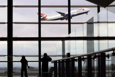 Passageiros no aeroporto de Heathrow, em Londres, observam decolagem de Boeing 747 de  British Airways. A British Airways passenger jet takes off from Terminal 5, at Heathrow Airport, west of London, on October 29, 2010.  British Airways on Friday posted net profits of 107 millions pounds for the first six months of the groups financial year, its first interim profit for two years, as revenues rose and non-fuel costs fell.  The impressive result, equivalent to 122 millions euros or 170 million dollars, compared with a net loss of 217 million pounds in the six months to September 2009, the airline said in a results statement.           AFP PHOTO/BEN STANSALL<!-- NICAID(6347884) -->