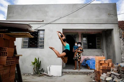  PORTO ALEGRE, RS, BRASIL, 28-12-2020: A bailarina Marielly da Cruz, 16 anos, em frente de casa com a mae, Joana DArc da Cruz e o sobrinho Pedro Henrique, no bairro Restinga. A residencia tinha diversos problemas estruturais e foi reformada gracas a uma campanha organizada por professoras e voluntarias. Por meio da danca, a jovem expressou as fragilidades do lar em busca de ajuda. Ela mora com a mae, tres irmaos e um sobrinho. Antes, a chuva entrava na casa pelos buracos nas telhas. Agora, a familia ja tem quartos e sala em melhores condicoes, mas a reforma ainda necessita de recursos para ser concluida em 2021. (Foto: Mateus Bruxel / Agencia RBS)Indexador: Mateus Bruxel<!-- NICAID(14678406) -->