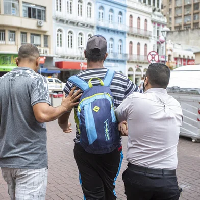 PORTO ALEGRE, RS, BRASIL - Homem (camiseta listrada de mochila nas costas) rouba celular no Centro de Porto Alegre e é contido por populares que encaminham ele até o Posto da BM, após isso homem é encaminhado até o Palácio da Polícia e é preso.Indexador: Jefferson Botega<!-- NICAID(14714843) -->