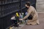 A woman lays a bunch of flowers at the gates of Buckingham Palace in central London on April 9, 2021 after the announcement of the death of Britains Prince Philip, Duke of Edinburgh. - Queen Elizabeth IIs husband Prince Philip, who recently spent more than a month in hospital and underwent a heart procedure, died on April 9, 2021, Buckingham Palace announced. He was 99. (Photo by Tolga Akmen / AFP)<!-- NICAID(14753914) -->