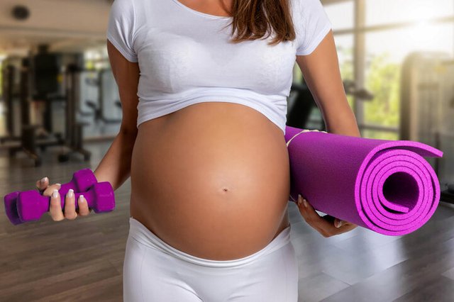 Conceito da gravidez e da aptidão física: Mulher grávida com esteira de Yoga no Fitness StudioFonte: 226491553<!-- NICAID(14325216) -->