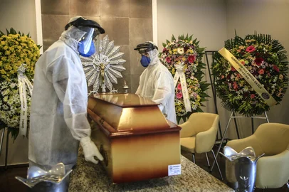 PORTO ALEGRE, RS, BRASIL - 2021.03.03 - Cemitérios registram alta no número de enterros por covid-19. Na foto: Funcionários paramentados preparam caixão de vítima de covid-19, de 83 anos, para sepultamento, no cemitério João XXIII.(Foto: ANDRÉ ÁVILA/ Agência RBS)Indexador: Andre Avila<!-- NICAID(14726992) -->