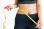 Close up shot woman with slim body measuring torsoClose up shot of woman with slim body measuring her waistline and torso. Healthy nutrition and weight losing concept.Fonte: 233714604<!-- NICAID(14789585) -->