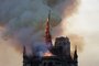 The steeple engulfed in flames collapses as the roof of the Notre-Dame de Paris Cathedral burns on April 15, 2019 in Paris. - A colossal fire swept through the famed Notre-Dame Cathedral in central Paris on April 15, 2019, causing a spire to collapse and raising fears over the future of the nearly millenium old building and its precious artworks. The fire, which began in the early evening, sent flames and huge clouds of grey smoke billowing into the Paris sky as stunned Parisians and tourists watched on in sheer horror. (Photo by Geoffroy VAN DER HASSELT / AFP)